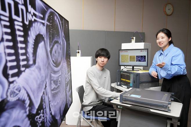 LG유플러스와 포항공과대학교(POSTECH) 홍원빈 교수 연구팀 연구원들이 액자 형태의 분산형 지능형 표면(RIS)에 전파를 발사하고 통신품질을 측정하고 있다.(사진=LG유플러스)