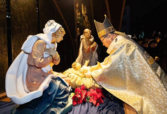 천주교 서울대교구장 정순택 대주교가 성탄절인 25일 새벽 서울 중구 명동대성당 앞마당에서 아기 예수를 말 구유에 안치하는 '구유 예절' 의식을 행하고 있다./공동취재단