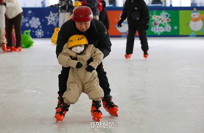‘노원 씽씽 눈썰매장’에 마련된 스케이트장에서 한 어린이가 아버지 품에 안겨 스케이트를 타고 있다.