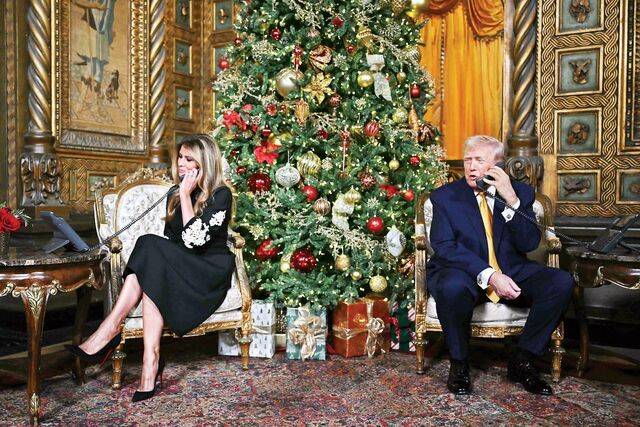 도널드 트럼프 미국 대통령과 부인 멜라니아 여사가 24일(현지시간) 플로리다주 팜비치 마러라고 클럽에서 북미항공우주방위사령부(NORAD)의 산타 추적 통화 이벤트에 참여해 전화로 어린이들의 질문에 답하고 있다. AFP연합뉴스
