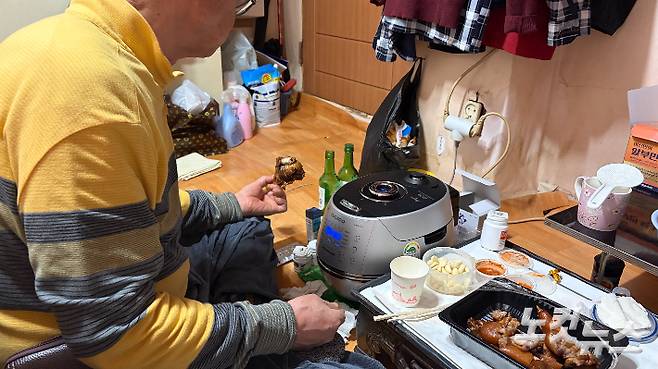 박상봉씨가 크리스마스 이브를 맞아 시장에서 사온 족발과 식사를 하고 있다. 박인 기자