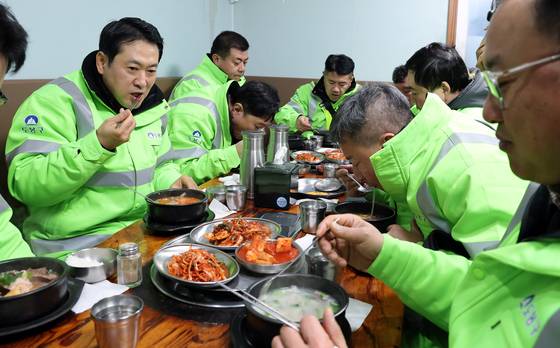 국민의힘 장동혁 대표가 26일 서울 도봉구 일대에서 생활폐기물 상차와 가로청소 봉사활동을 마친 뒤 환경공무관들과 국밥을 함께하며 조찬 간담회를 갖고 있다. 연합뉴스