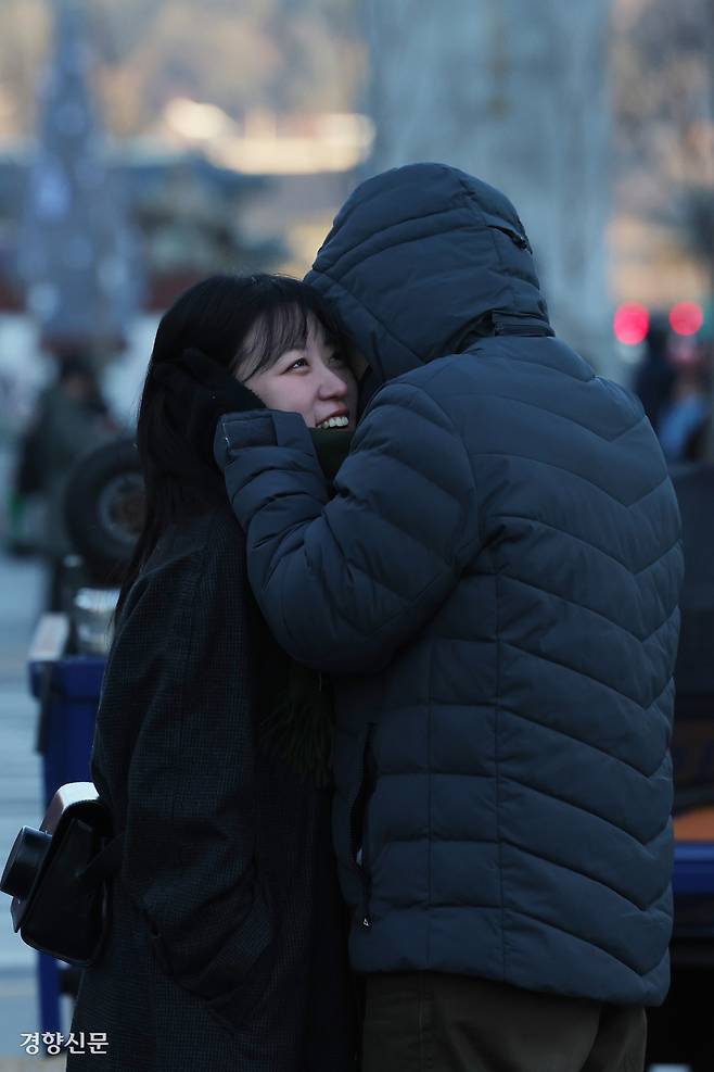 26일 서울 중구 세종대로에서 한 시민이 연인의 귀를 감싸주고 있다.