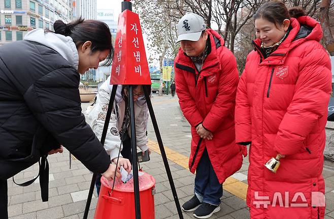 [인천=뉴시스] 전진환 기자 = 16일 오후 인천 미추홀구 롯데백화점 앞 사거리에서 학생들이 구세군 자선냄비에 성금을 넣고 있다. 2025.12.16. amin2@newsis.com