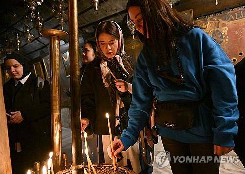 베들레헴 성당의 촛불 (베들레헴 <팔레스타인 서안지구> 2025년 12월 23일 예수 탄생지로 알려진 팔레스타인 서안지구 베들레헴의 예수 탄생 기념 성당에서 사람들이 촛불을 켜고 있다. (Photo by Debbie Hill/ UPI) 2025.12.26.
