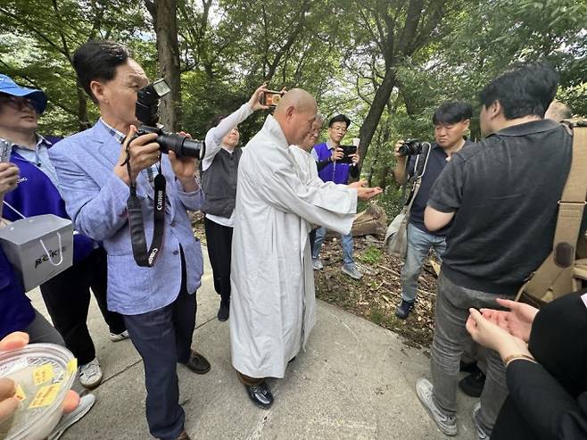 2025년 6월 경남 밀양 표충사에서 열린 비단벌레 방사 행사에서 표충사 주지가 비단벌레를 숲에 풀어주고 있다. 숲속의작은친구들 제공