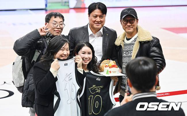 [OSEN=울산, 이석우 기자]  On the 27th, the 2025-2026 LG Electronics professional basketball game between Ulsan Hyundai Mobis and Suwon KT was held at Dongcheon Gymnasium in Ulsan. Suwon KT defeated Ulsan Hyundai Mobis 78-75 and escaped a three-game losing streak. Suwon KT coach Moon Kyung-eun is taking a commemorative photo with fans who presented him with a congratulatory cake after recording his 7th 300th win in history. 2025.12.27 / foto0307@osen.co.kr