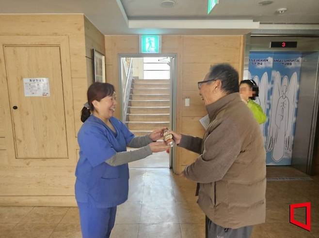 지난달 26일 서울 동대문구 전농동 다일작은 천국에서 입소인 민기동씨(82)가 조미진 간호팀장에게 음료를 건네고 있다.