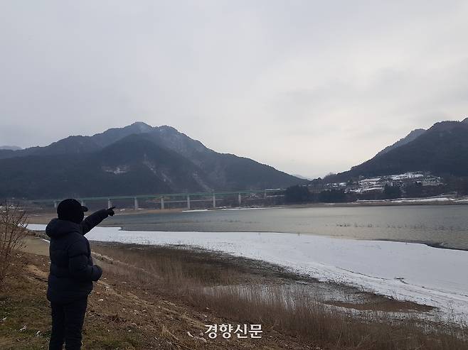 28일 오전 강원 인제군 남면 소양호 상류 부평지구의 ‘빙어호’ 둔치에서 한 주민이 얼음이 얼지 않은 강물을 손으로 가리키고 있다.  빙어호는 겨울철 빙어 얼음낚시를 테마로 한 ‘인제 빙어축제’가 열리는 곳이다. 최승현 기자