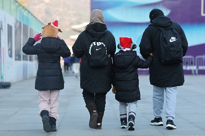 A family is seen walking along Gwanghwamun Square in Jongno District, central Seoul, on Dec. 25. [YONHAP]