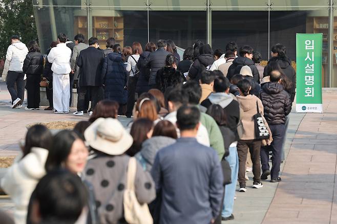 Parents line up in front of Jongno Hagwon in Jongno-gu, Seoul, on Dec. 7, to participate in a session where experts explain admissions strategy for suneung test-takers. (Yonhap)
