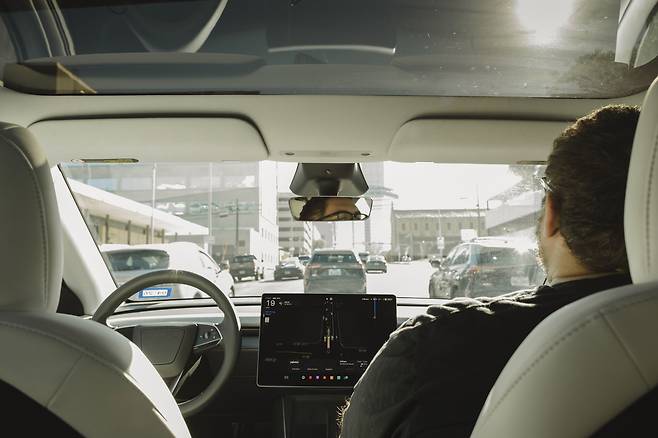 A Tesla robotaxi drives with a safety monitor sitting in the passenger seat in Austin, Dec. 9, 2025. Shares of Tesla have hit new highs on optimism about the company’s self-driving taxis. But experts say Tesla is far behind Waymo, which has a big head start. (Ariana Gomez/The New York Times)
