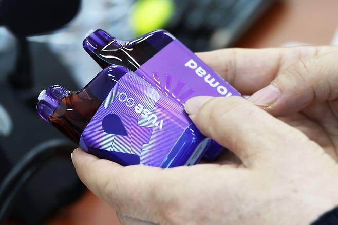 A person holds up e-cigarettes, or vapes, during a National Assembly session at the National Assembly in Yeouido, western Seoul on Feb. 18. [NEWS1]