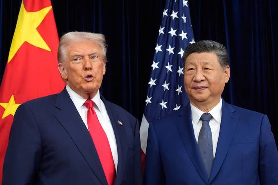U.S. President Donald Trump, left, and Chinese President Xi Jinping pose together ahead of their summit at Gimhae International Airport in Busan on Oct. 30. [AP/YONHAP]