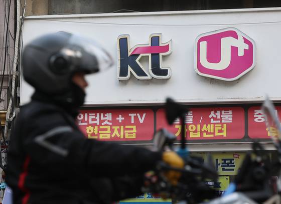 A telecom store in Seoul displays the logos of KT and LG U+ on Dec. 29. [YONHAP]
