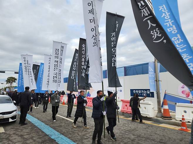 12·29 제주항공 여객기 참사 1주기를 하루 앞둔 28일 오후 3시 30분경 무안국제공항에서 시민단체 회원과 학생 등 참가자 300여명이 '정부가 진상규명에 나설 것'을 촉구하는 깃발을 들고 행진하고 있다. ⓒ시사저널 정성환
