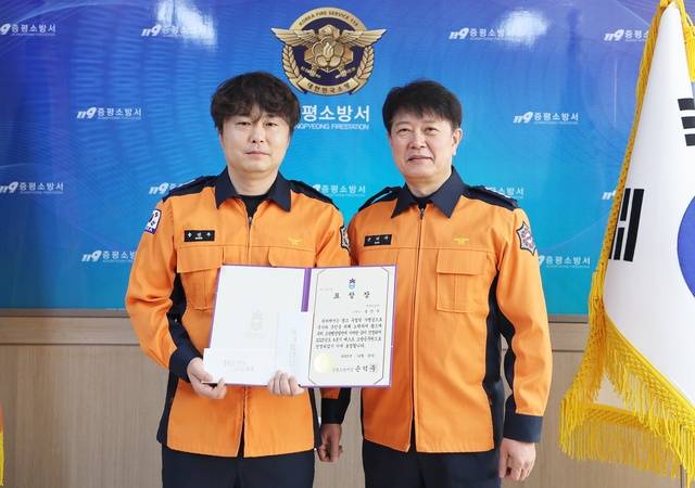 ▲ 증평소방서 송진우 소방교(왼쪽)가 올해의 베스트소방공무원 표창을 받고 손덕주 서장과 기념촬영하고 있다. /증평소방서 제공