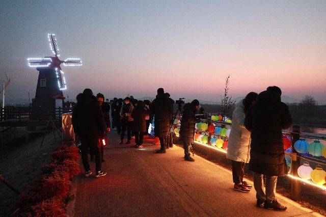 솥바위에 몰려든 해맞이 인파들이 소원지를 작성하여 데크 소망등에 달고 있다./의령군/