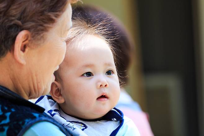 튼실한 아이를 돌보고 있는 할머니. 주로 맞벌이 자녀를 위해 손주를 돌보는 나이든 사람의 관절은 항상 '비상 사태'다. 육아 틈틈이 5분 스트레칭을 하는 게 좋다. 자녀와 협의해 육아 시간 자체를 적절히 조정하는 것도 필요하다. 사진=게티이미지뱅크