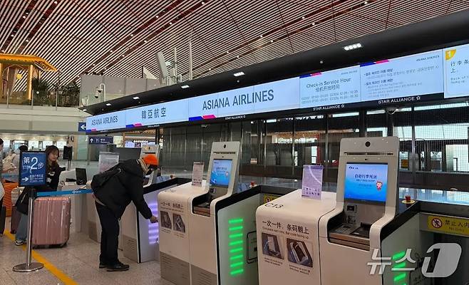 30일 중국 베이징공항 제3터미널에 아시아나항공 셀프 체크인 서비스를 돕는 탑승권 키오스크와 셀프 백드롭 기기가 놓인 모습(아시아나항공 제공). 2025.12.30.