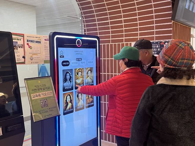 Visitors at Seoul Inclusive Digital Plaza in Gangdong District, eastern Seoul, select themes for photos in which they are transformed into different styles by artificial intelligence on Dec. 18. [CHO JUNG-WOO]