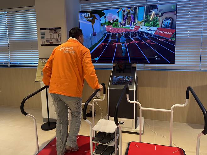 A staff member demonstrates an interactive game that requires users to step on a pad at Seoul Inclusive Digital Plaza in Gangdong District, eastern Seoul, on Dec. 18. [CHO JUNG-WOO]