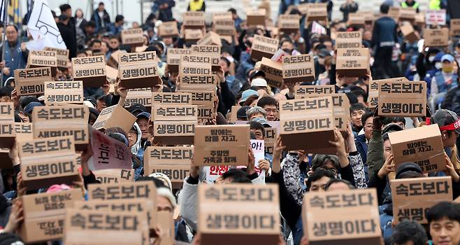 Delivery workers carry signs with the slogan ″Life over speed″ during a protest in front of Dongsipjagak Pavilion in central Seoul on Nov. 23. [NEWS1]