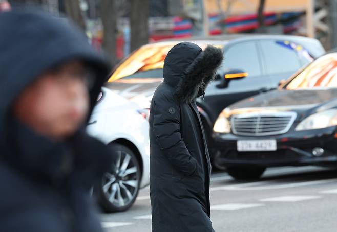People are seen in the cold near Gwanghwamun Square in Jongno District, central Seoul on Dec. 30. [YONHAP]