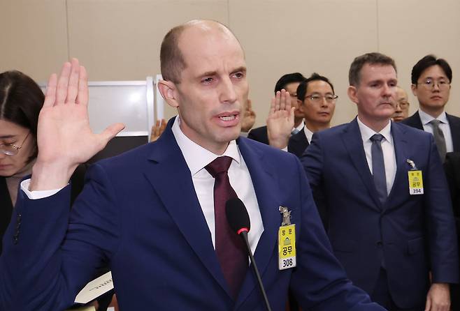 Coupang interim CEO Harold Rogers, center, takes an oath during a parliamentary hearing at the National Assembly in Yeouido, western Seoul, on Dec. 30. [NEWS1]