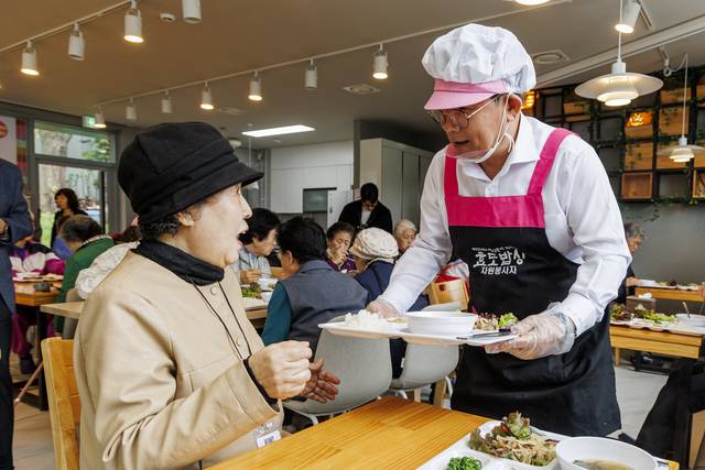 박강수(오른쪽) 마포구청장이 어르신께 식사를 대접하고 있다. 마포구청 제공