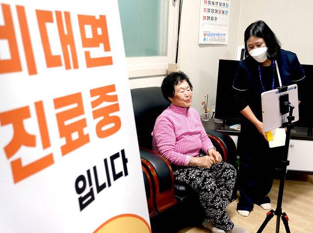 전북 남원시 금지면 용전경로당에서 정보순씨(76)가 마경미 방문간호사(오른쪽)의 도움을 받아 영상통화로 비대면 진료를 받고 있다. 남원시