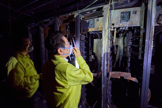 This file photo provided by the presidential office shows President Lee Jae Myung (C) taking a look around the National Information Resources Service in the central city of Daejeon on Oct. 10, following a fire at the data center. (Yonhap)