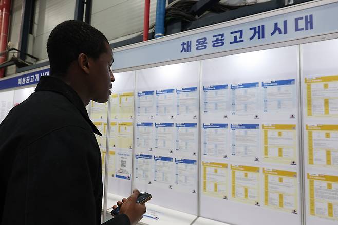 Jobseekers look at a job board on Dec. 20 at a job fair held in Gangnam-gu, Seoul. (Yonhap)