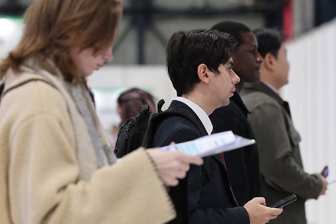 Jobseekers look at a job board on Dec. 20 at a job fair held in Gangnam-gu, Seoul. (Yonhap)