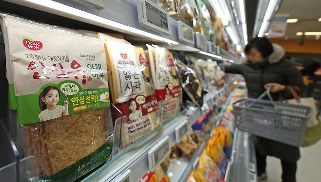A consumer buys processed food at a market in Seoul on Dec. 31. [NEWS1]