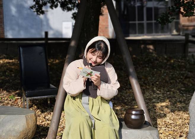 광주 양림동 연극 투어 중&nbsp;호랑가시나무 아래 김치 항아리와 함께 앉아 있는&nbsp;‘복순’.