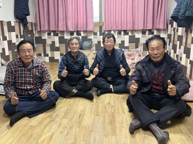 지난달 31일 신안군 압해읍 신용1리 마을회관에 주민들이 모여 엄지를 치켜들고 미소를 지어보이고 있다.  /신안=윤준명 기자 yoon@