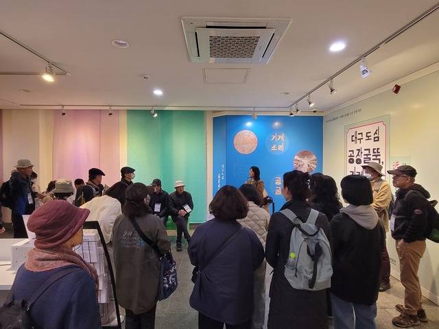 대구근대역사관에서 2025년에 열린 대구 근대 섬유 특별기획전을 찾은 관람객들이 해설자의 설명을 듣고 있다.