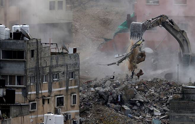 31일(현지시각) 서안지구 도시 툴라켐 인근 누르샴스 난민촌에서 이스라엘군이 굴착기로 건물들을 철거하고 있다. EPA 연합뉴스
