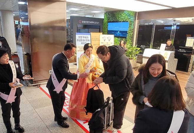 새해 첫날 제주국제공항에서 열린 환영 행사에서 관계자들이 입도객들에게 기념품을 전달하고 있다. (제주도관광협회 제공