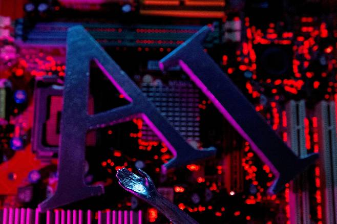 AI letters and a robot hand are atop a computer motherboard in this illustration created on June 23, 2023. [REUTERS/YONHAP]