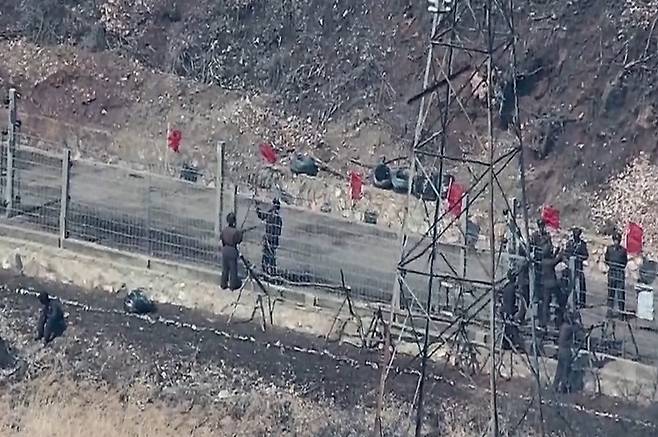 This file photo, provided by the Joint Chiefs of Staff on March 27, shows North Korean troops repairing fences at the eastern border. [JOINT CHIEFS OF STAFF]