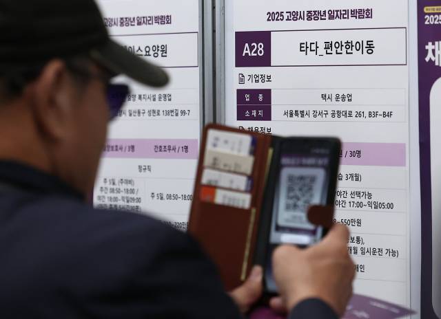 경기도 고양시 킨텍스에서 열린 2025 고양시 중장년 일자리 박람회에서 한 구직자가 채용 정보를 촬영하고 있다. 뉴스1