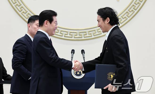 이재명 대통령이 2일 청와대 영빈관에서 열린 2026년 신년 인사회에서 신우석 돌고래유괴단 감독에게 국민훈장 목련장을 수여하고 있다. 2026.1.2/뉴스1 ⓒ News1 이재명 기자