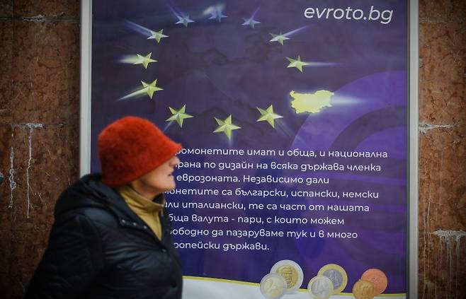 1일(현지시간) 불가리아 수도 소피아에서 한 여성이 불가리아의 21번째 유로존 가입을 알리는 포스터 옆을 지나고 있다.AP뉴시스
