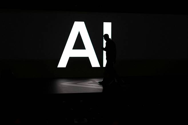 A screen reads 'AI' in reference to artificial intelligence as attendees gather during Rivian's first Autonomy and AI Day, showcasing developments in self-driving technology, in Palo Alto, California, on Dec. 11, 2025. [REUTERS/YONHAP]