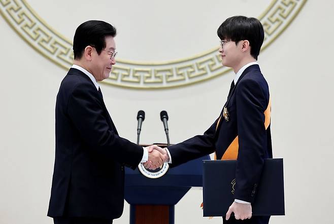 이재명 대통령이 2일 청와대 영빈관에서 열린 신년 인사회에서 프로게이머 ‘페이커’ 이상혁에게 체육훈장 청룡장을 수여하고 있다. 연합