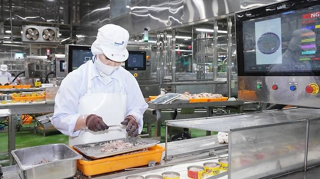 창원 동원F&B 공장에서 작업자가 인공지능(AI)이 걸러낸 참치 캔을 살펴보고 있다. [사진제공=동원F&B]
