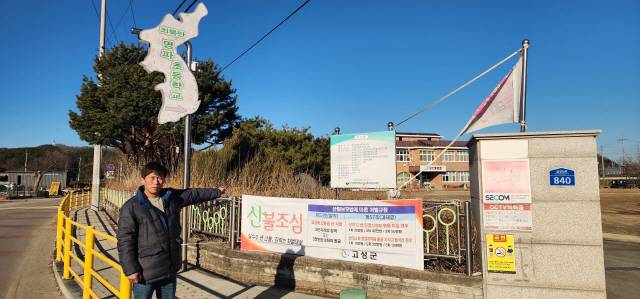 ▲ 김남명 고성 명파리 이장이 폐교가 된 모교인 명파분교장을 가리키고 있다.