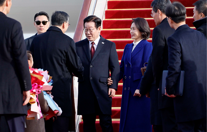 3박4일간 중국을 국빈방문하는 이재명 대통령과 김혜경 여사가 4일 중국 베이징 서우드공항에서 환영객들과 인사하고 있다. [베이징 김호영 기자]